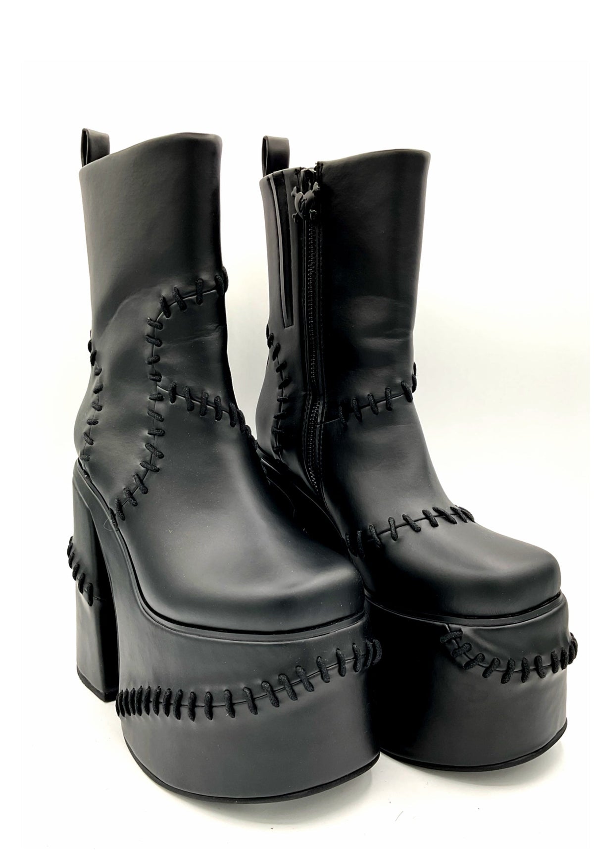 Black platform boots with detailed stitching on a white background