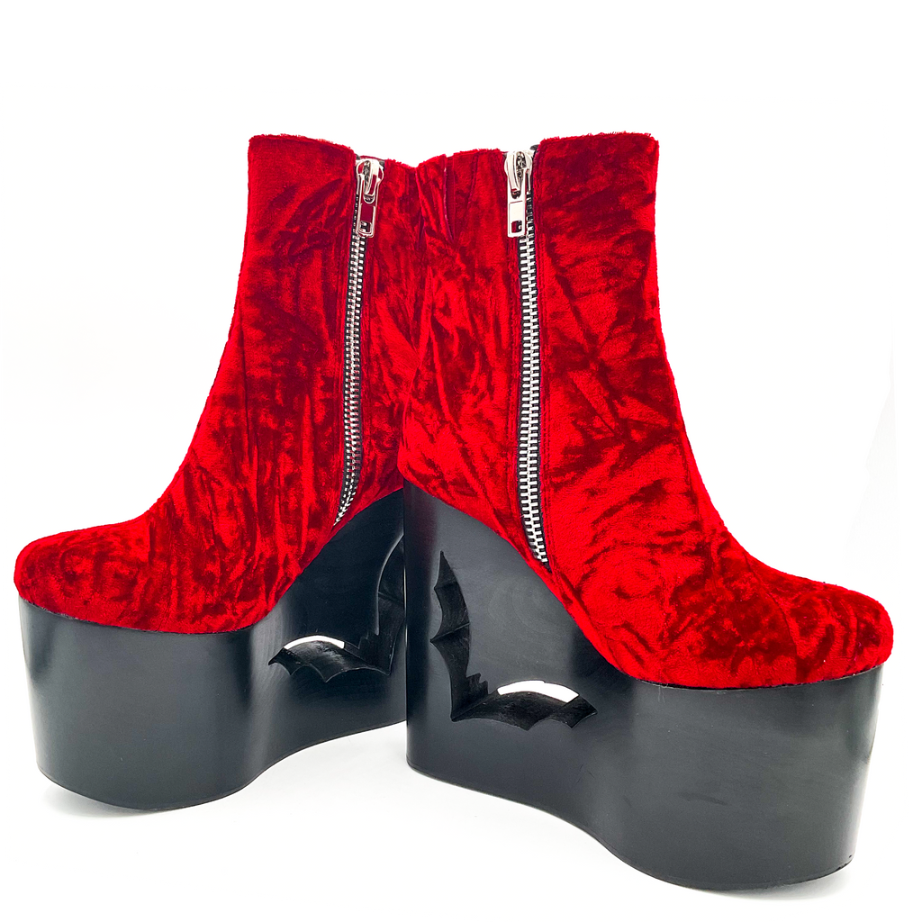 Red platform boots with zippers on a white background